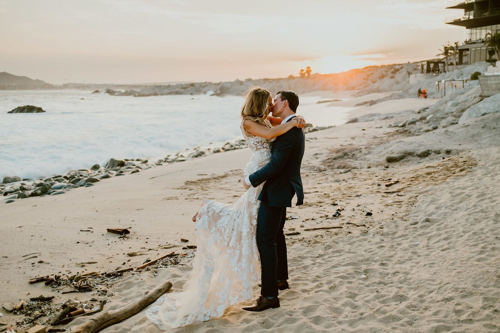 Bride and Groom kissing during photo session in Cabo San Lucas Mexico right in front of the Cape by Thompson Hotels. Wedding Planning by Cabo Wedding Services