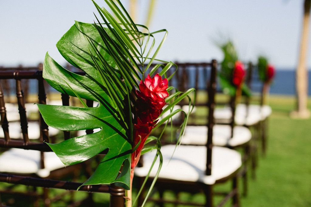 Chair decorations with Monstera Leafs, Ginger and Tropical Greenery at Wedding Ceremony in Los Cabos, Mexico. Wedding desgined and planned by Cabo Wedding Services