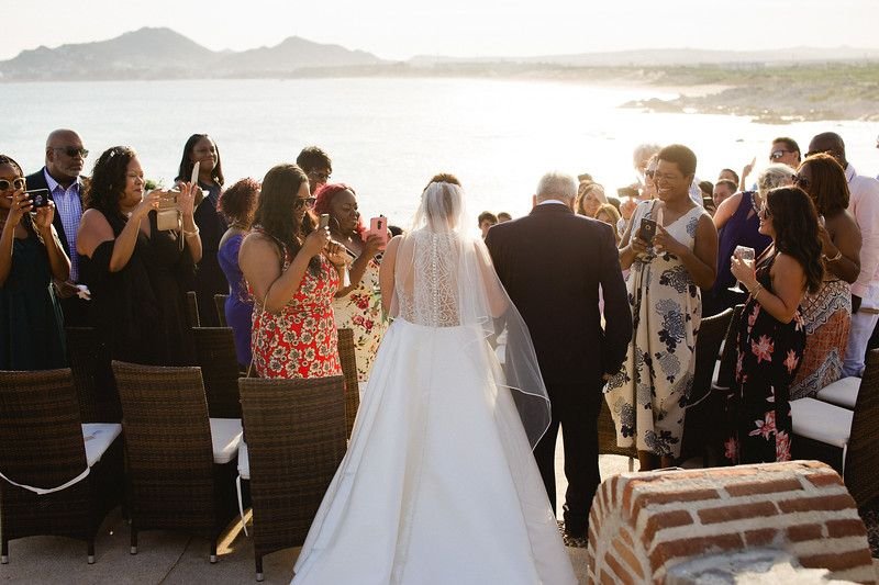 Bride walking down to her wedding ceremony at Wedding Venue Sunset da Mona Lisa in Cabo San Lucas, Mexico. Wedding Planning and design by Cabo Wedding Services