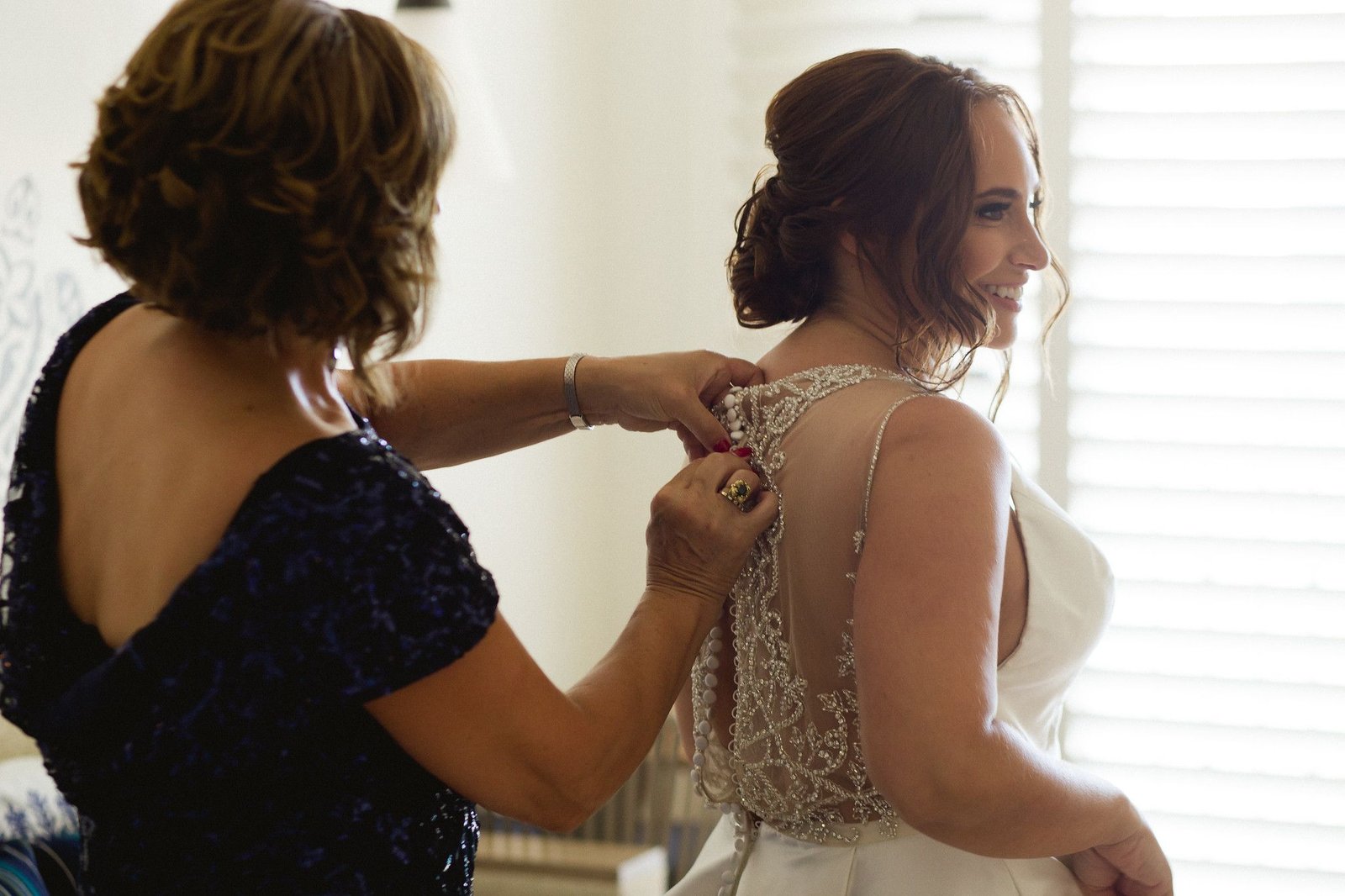 Bride on her wedding day getting ready and putting her dress on. She was staying at Hilton Los Cabos and that is where she got ready and Alma Vallejo with Cabo Makeup did her Hairstyle and Makeup. Cabo Wedding Services did their Wedding Planning and design