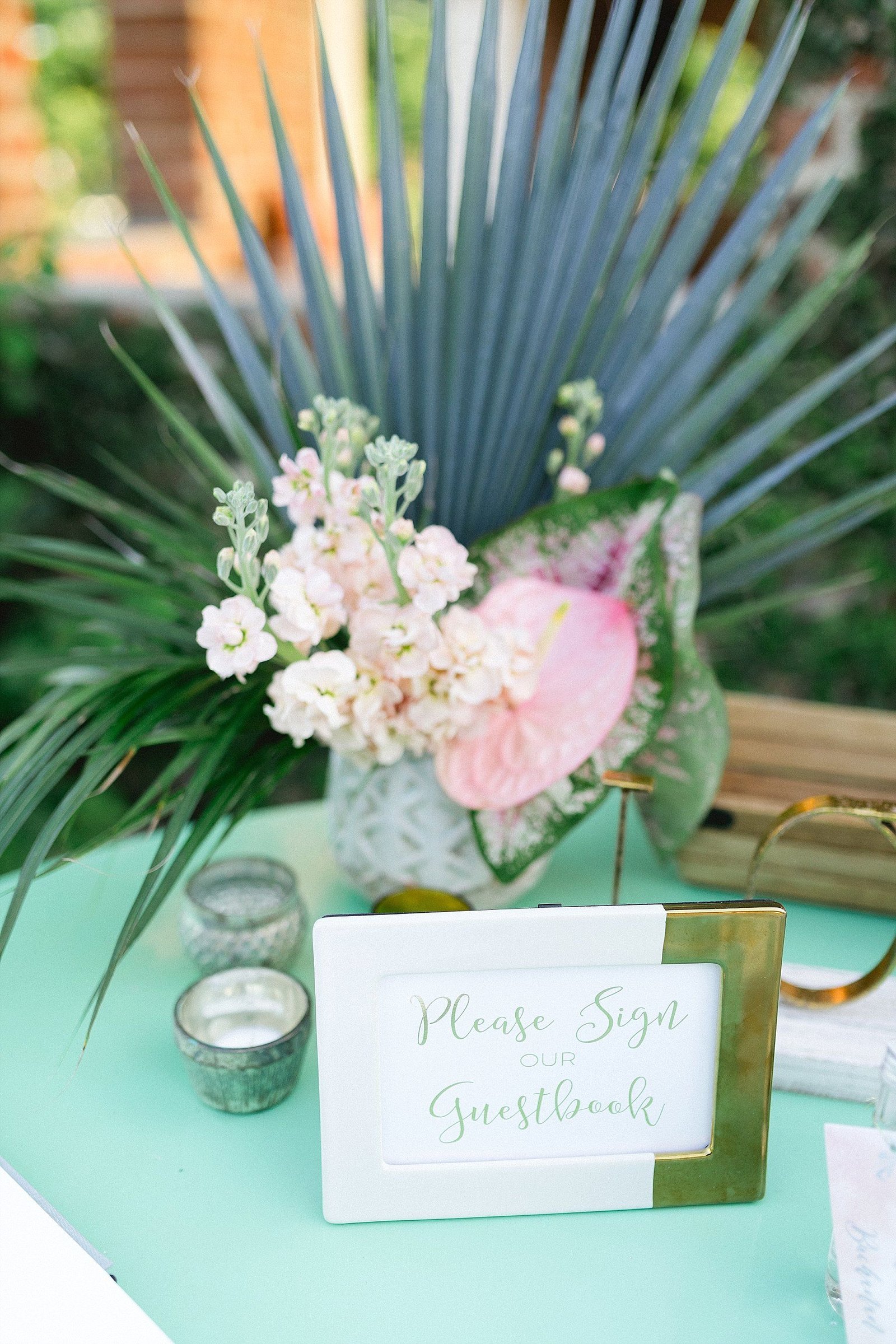 Guest signing book table with a floral arrangement. The Wedding took place at Flora Farms in Los Cabos, Mexico. Wedding Planning by Cabo Wedding Services. Photography by Sara Richardson