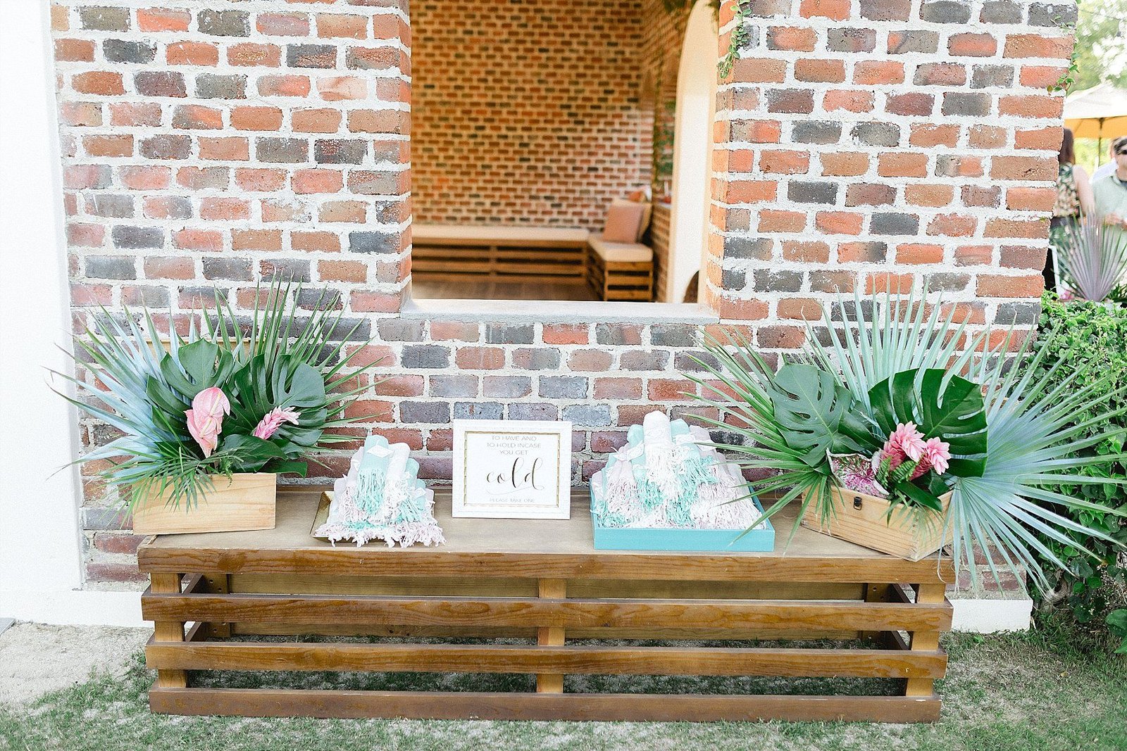 Pashmina setup with flower arrangements on bench. Great to do when the weather can be a bit chilly and works great for wedding favors. Wedding Planning by Cabo Wedding Services and Wedding Photography done by Sara Richardson
