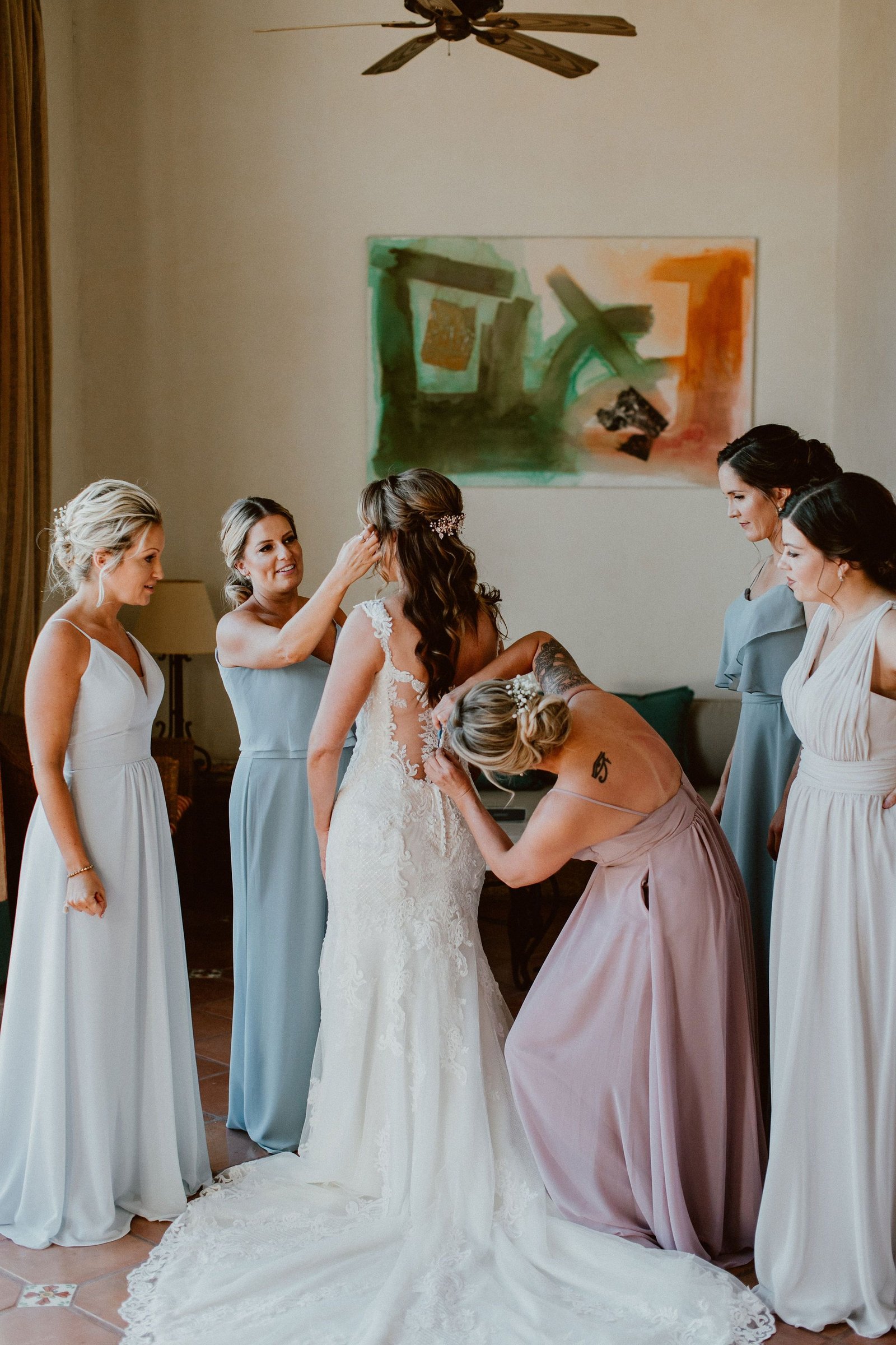 Bride getting ready with her Bridesmaids, getting her dress on. This was at her Bridal Suite in Cabo Del Sol, in Los Cabos, Mexico. This was January, 2019 and she hosted her wedding day with 50 of her closest Family and Friends, who most of them came from Oregon and Minnesota. 