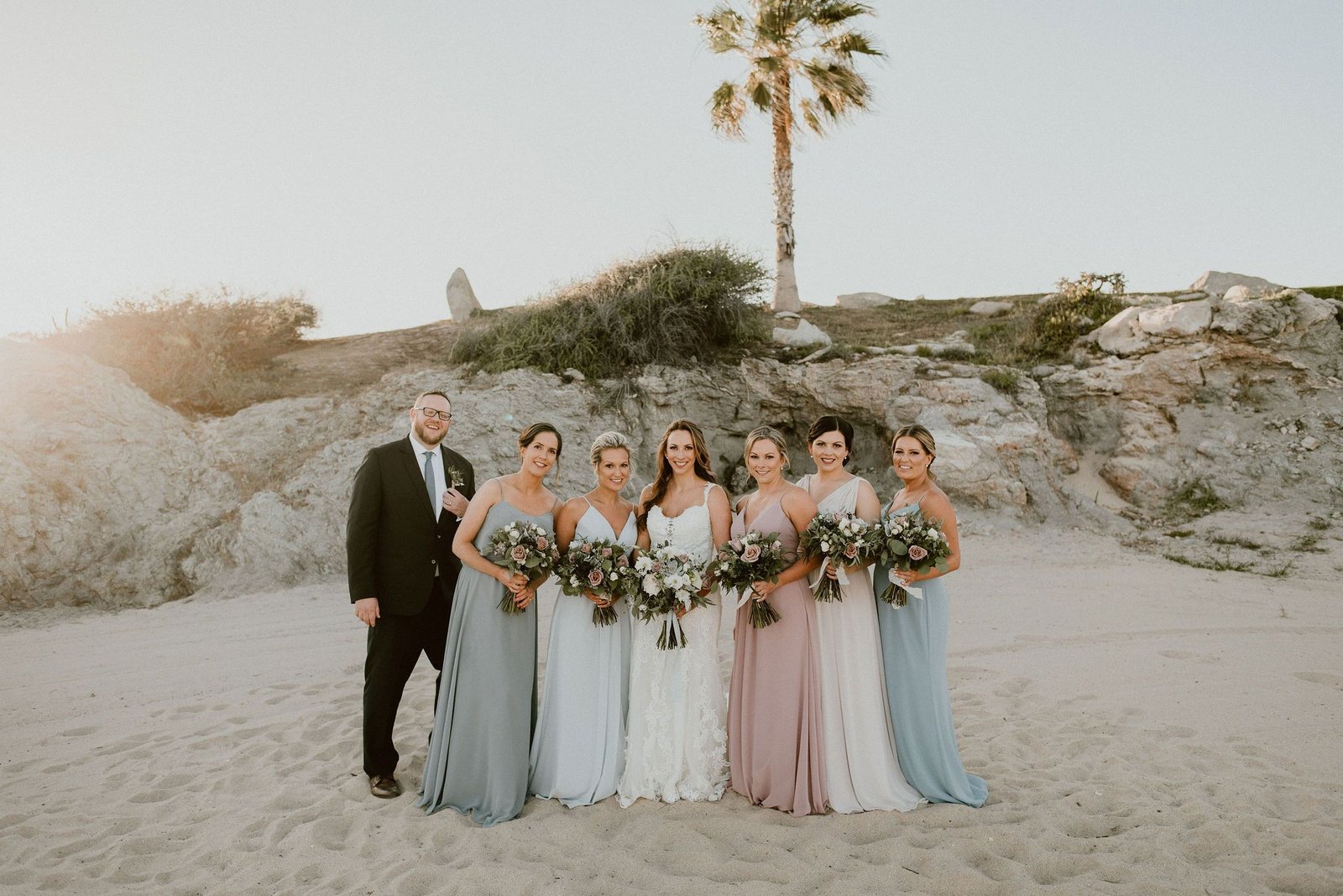 Bride with Bridesmaids at the Beach taking their Bridal Portraits with the Bridal Party. This was at Cabo del Sol in Cabo San Lucas, Mexico. Wedding Planning was done by Cabo Wedding Services.