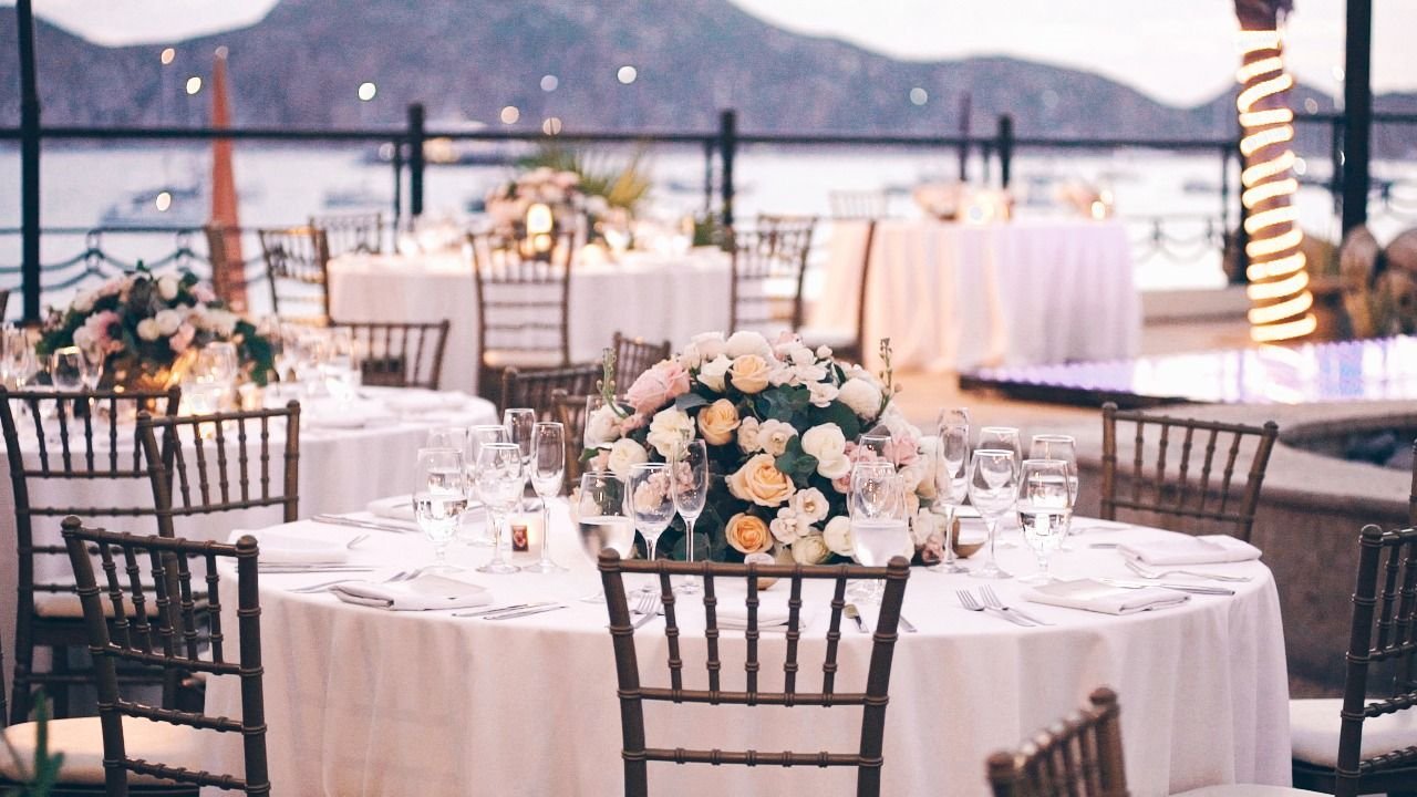 Table setup with flowers at Villa del Palmar in Los Cabos Mexico. The Wedding Reception took place at the Desert Terrace at the Villa Group in Los Cabos Mexico. Overlooking the Ocean, the Bride and Groom were able to have dinner with all of their close loved ones looking over the beautiful Medano Beach