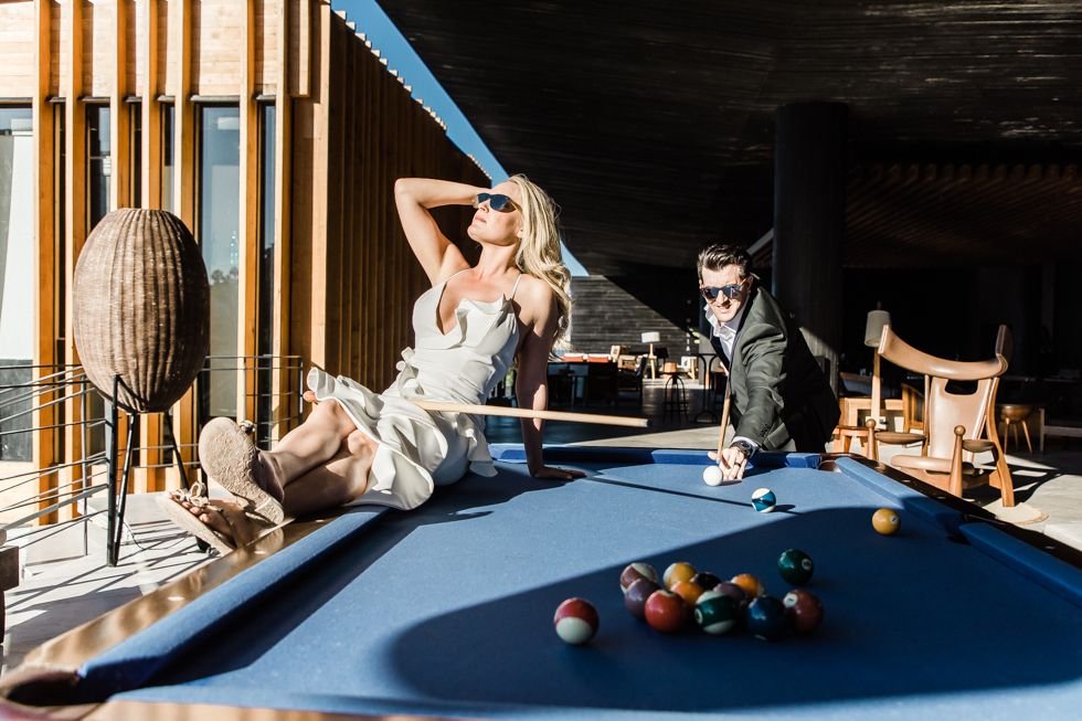 Bride and Groom posing by the pool table at The Cape by Thompson Hotels in Los Cabos Mexico. They had a great photo session with Photographer Daniel Jireh