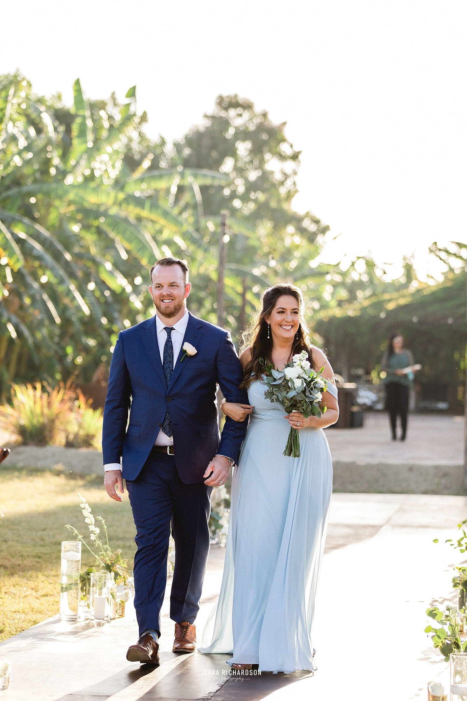Bridesmaid and Groomsman walking down the aisle, making way for the beautiful Bride. This wedding took place in February of 2019, in Los Cabos Mexico. It is one of the biggest wedding destinations in the world.