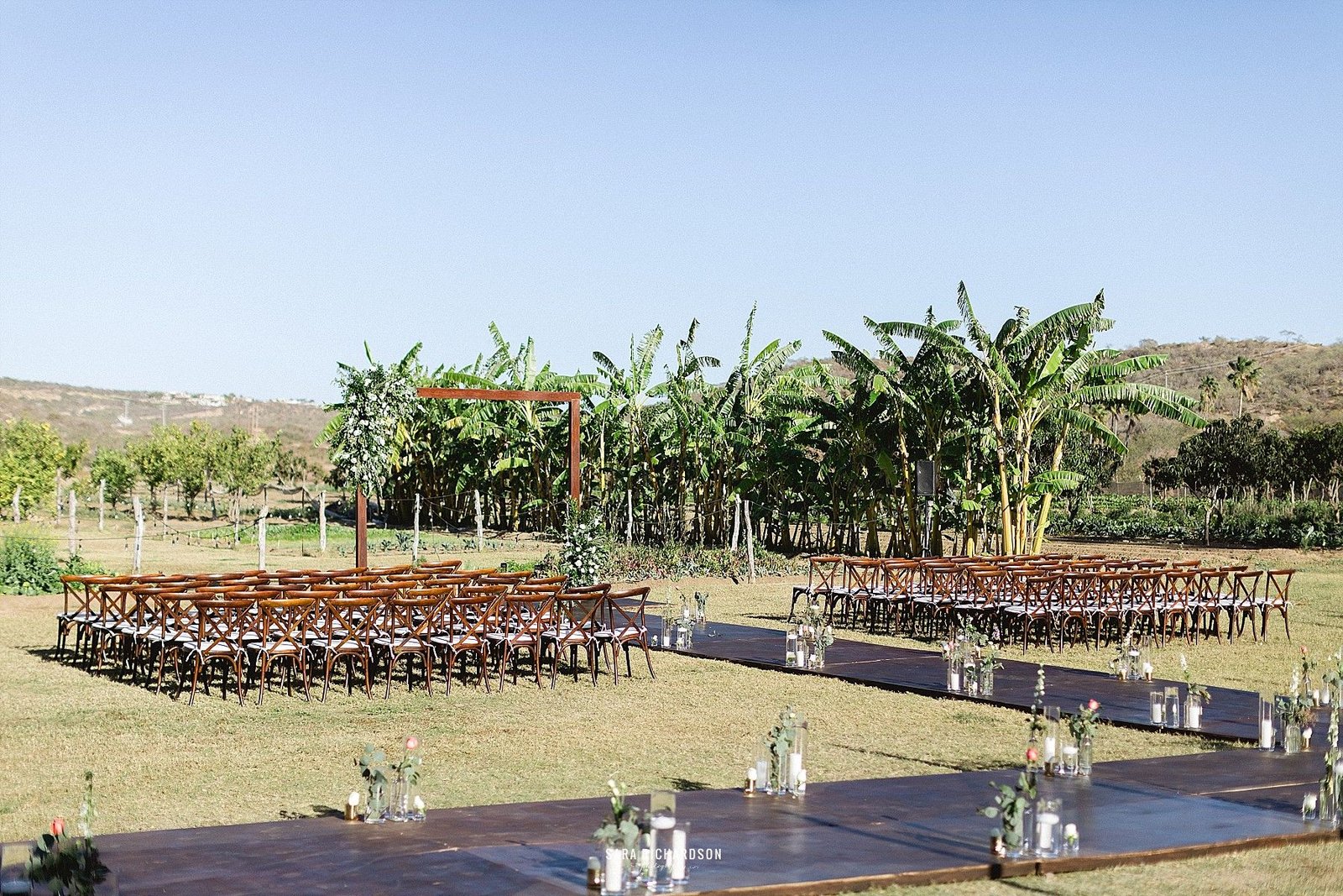 This is the Ceremony setting for Lindsey and Noel's Wedding. They decided to have a hard wooden floor for their guests so they do not have to walk in the grass, since most of them wore heels. We decided to decorate the aisle and make it look a little fuller.
