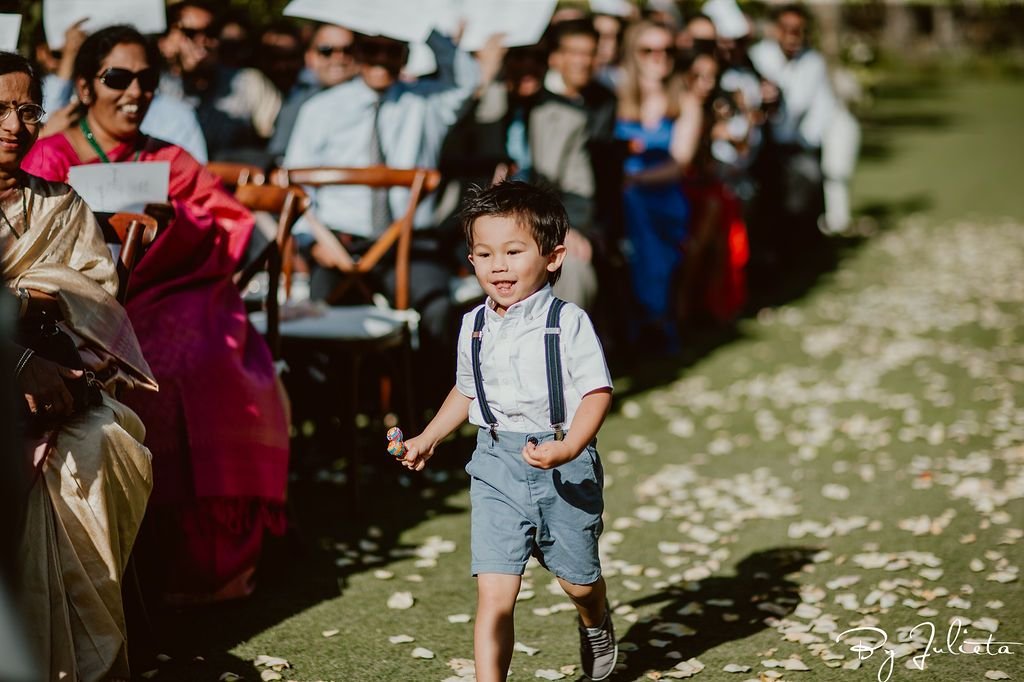 Ring Bearer running down the aisle at Wedding Venue Flora Farms in Los Cabos Mexico. Cabo Wedding Services did the Wedding Planning and Julieta Amezcua was the Photographer.