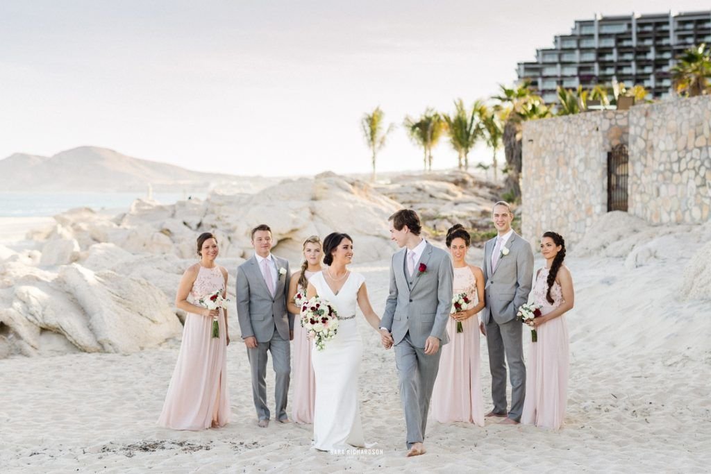 Bride and groom enjoying time with their bridal party on the beach in Los Cabos Mexico, at their Destination wedding at Villa las Rocas