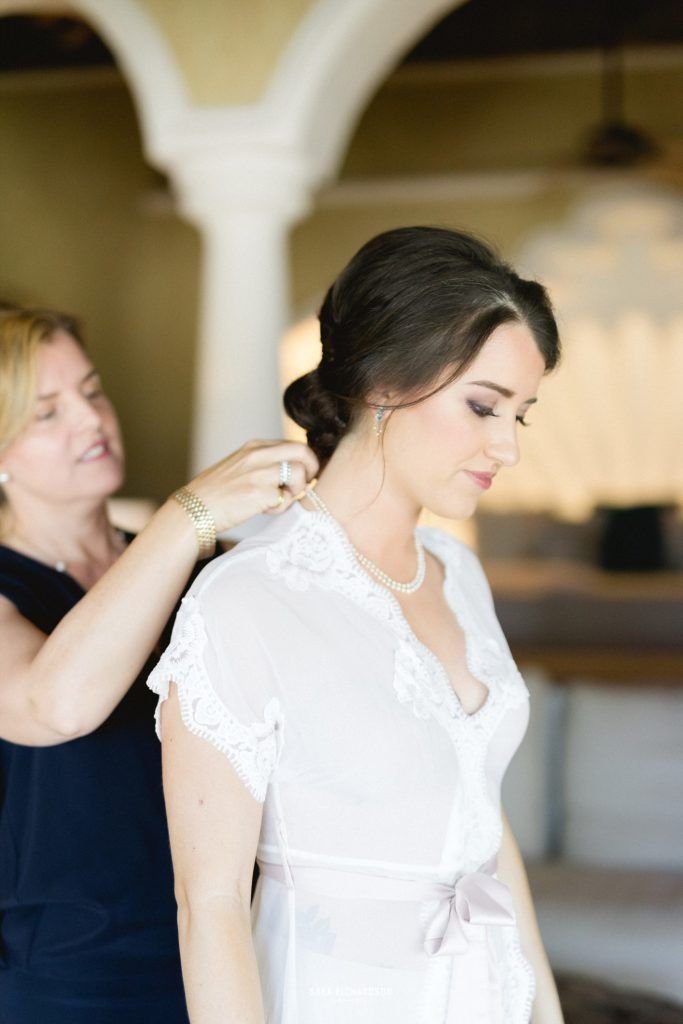 Bride getting ready with her mom at the villa she rented for her wedding weekend in Los Cabos Mexico. She had Sara Richardson as her photographer and Cabo Wedding Services as her wedding Planners. She wore a beautiful lose dress with Gucci perfume.