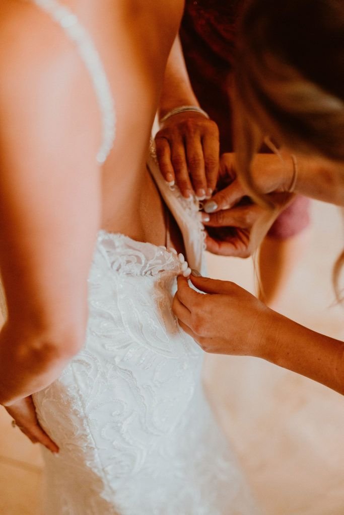 Mother of the Bride zipping up her daughter's dress on her wedding day. They were getting Ready at Pueblo Bonito Sunset Beach and got married at Acre Baja in Los Cabos Mexico. Wedding Planning was done by Jessica Wolff from Cabo Wedding Services