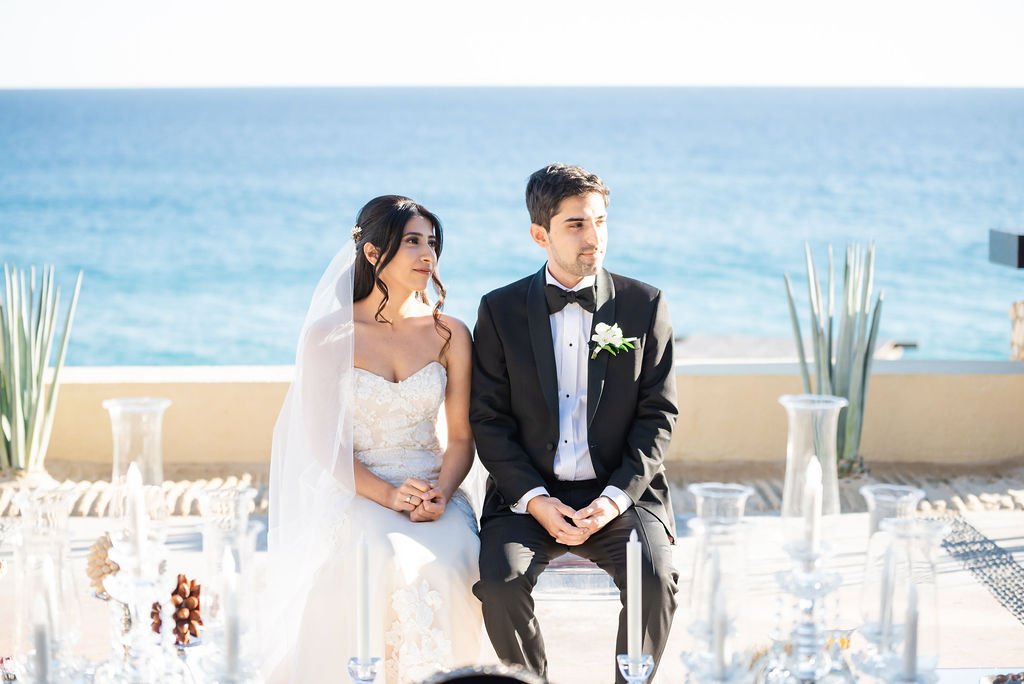 Bride and Groom sitting at their Sofreh on their wedding day in Los Cabos, Mexico. Wedding Planning was done by Jessica Wolff from Cabo Wedding Services.